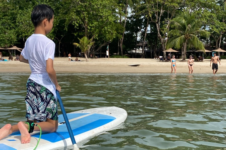 スタンドアップパドルボートで遊ぶ子供